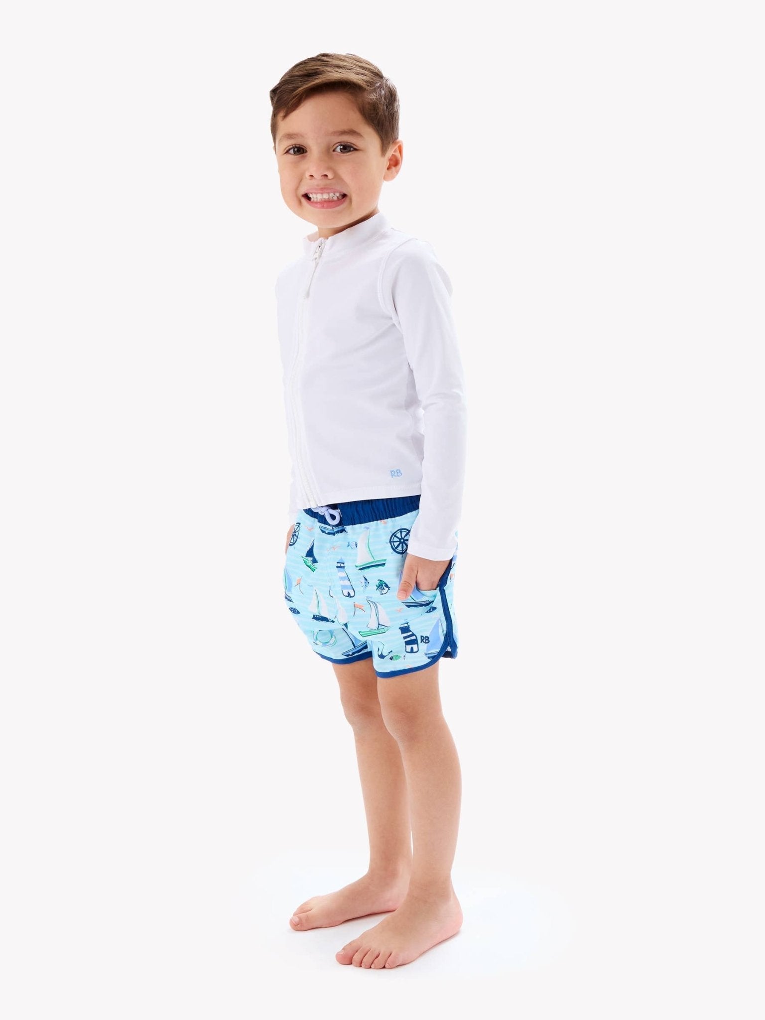 RuffleButts + RuggedButts - Boys Blue Sweet Sails Performance Hybrid Dolphin Hem Swim Trunks - For All Elements